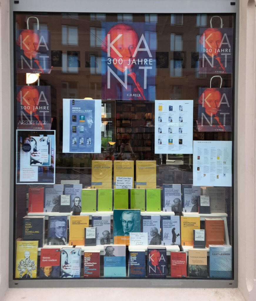 Ein Bild in einem Text mit dem Titel: Über den Blog. Ein Blog über das Jahrhundert. Zu sehen ist das Schaufenster einer Buchhandlung von Außen. In diesem Schaufenster sind Bücher über Immanuel Kant ausgestellt.
